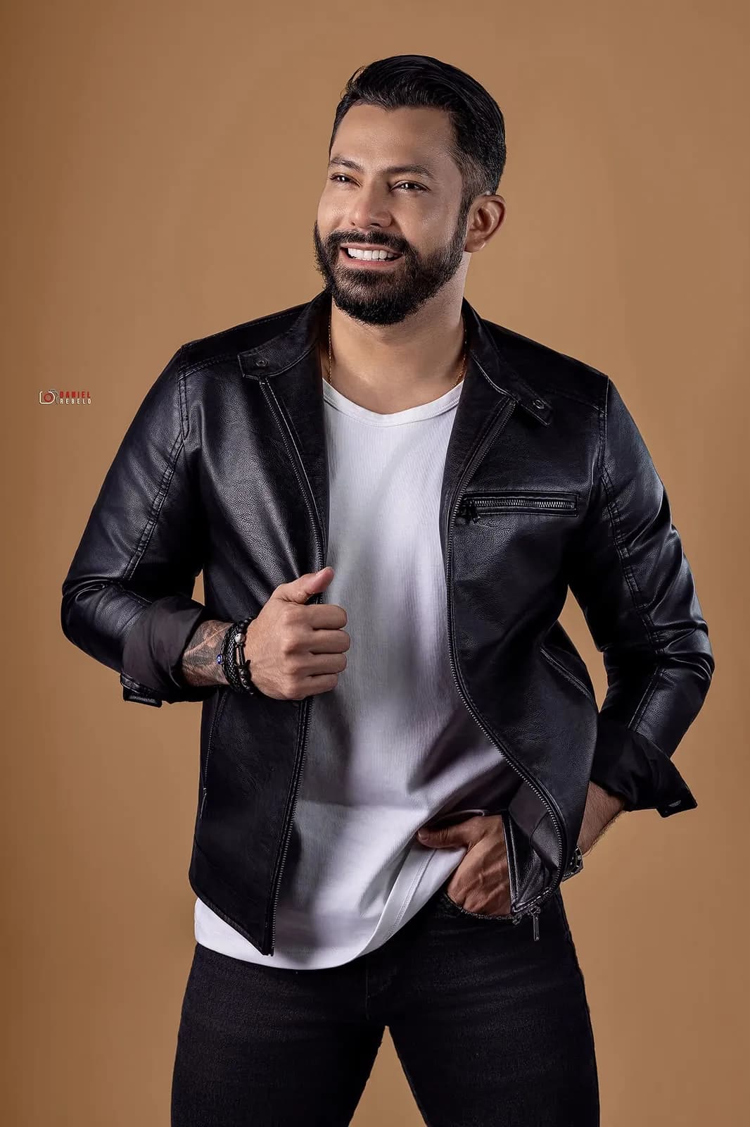 Lukas Santos de camiseta branca e jaqueta de couro, em estúdio