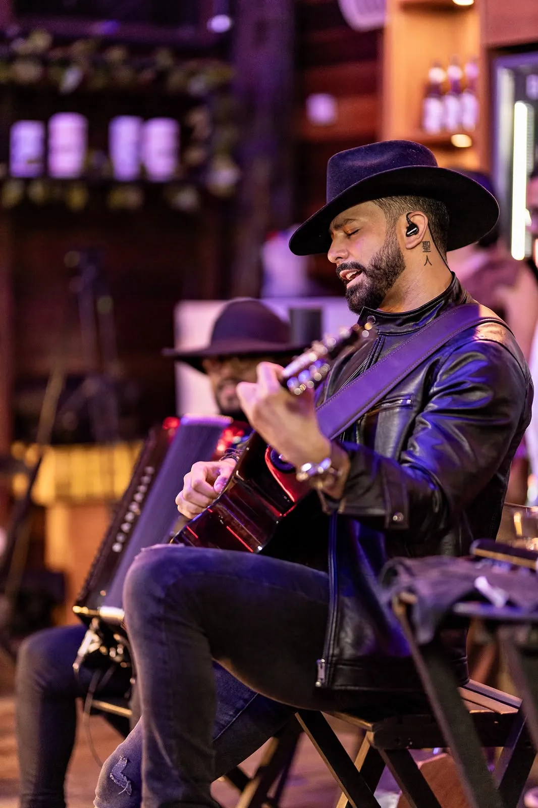 Lukas Santos tocando violão de chapéu